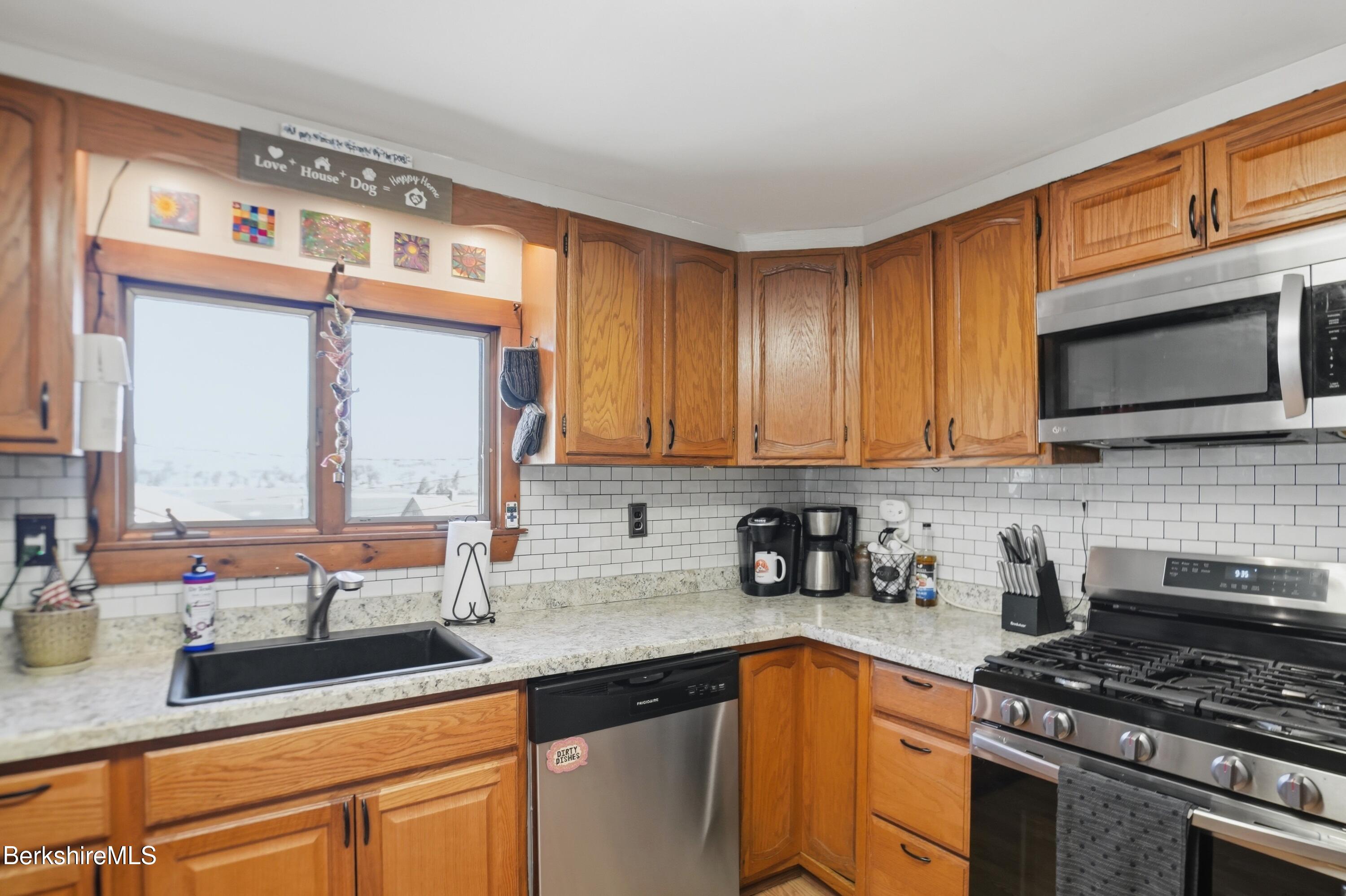 22 Broadway Street Pittsfield, MA 01201 - Photo 52 of 84 a kitchen with stainless steel appliances a sink dishwasher stove microwave and cabinets