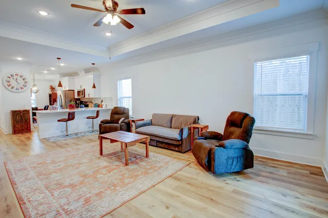 a living room with furniture a ceiling fan and a window