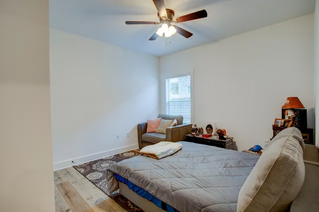 a bedroom with a bed and a chandelier fan