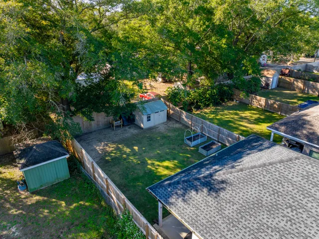 a backyard with table and chairs and a large tree