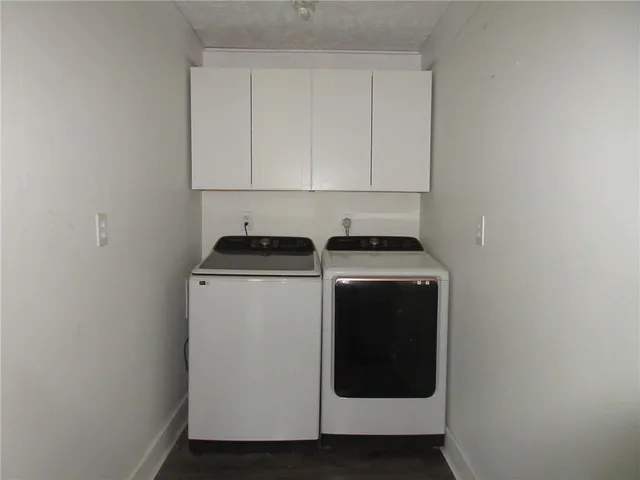 a utility room with wooden floor washer and dryer
