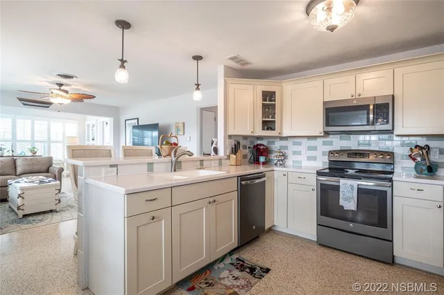 a kitchen with kitchen island granite countertop a sink cabinets and stainless steel appliances