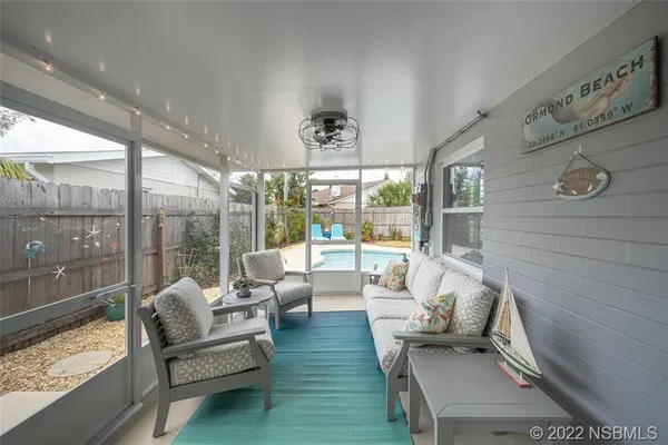 a living room with furniture and a floor to ceiling window