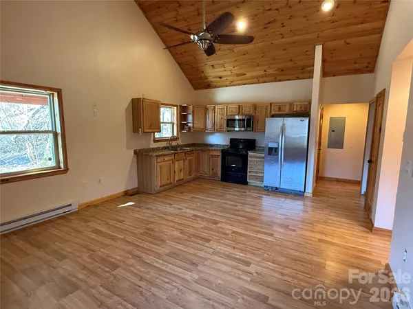 a view of a kitchen with a sink stove cabinets and empty room