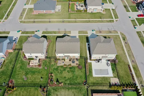 an aerial view of residential houses with outdoor space and street view