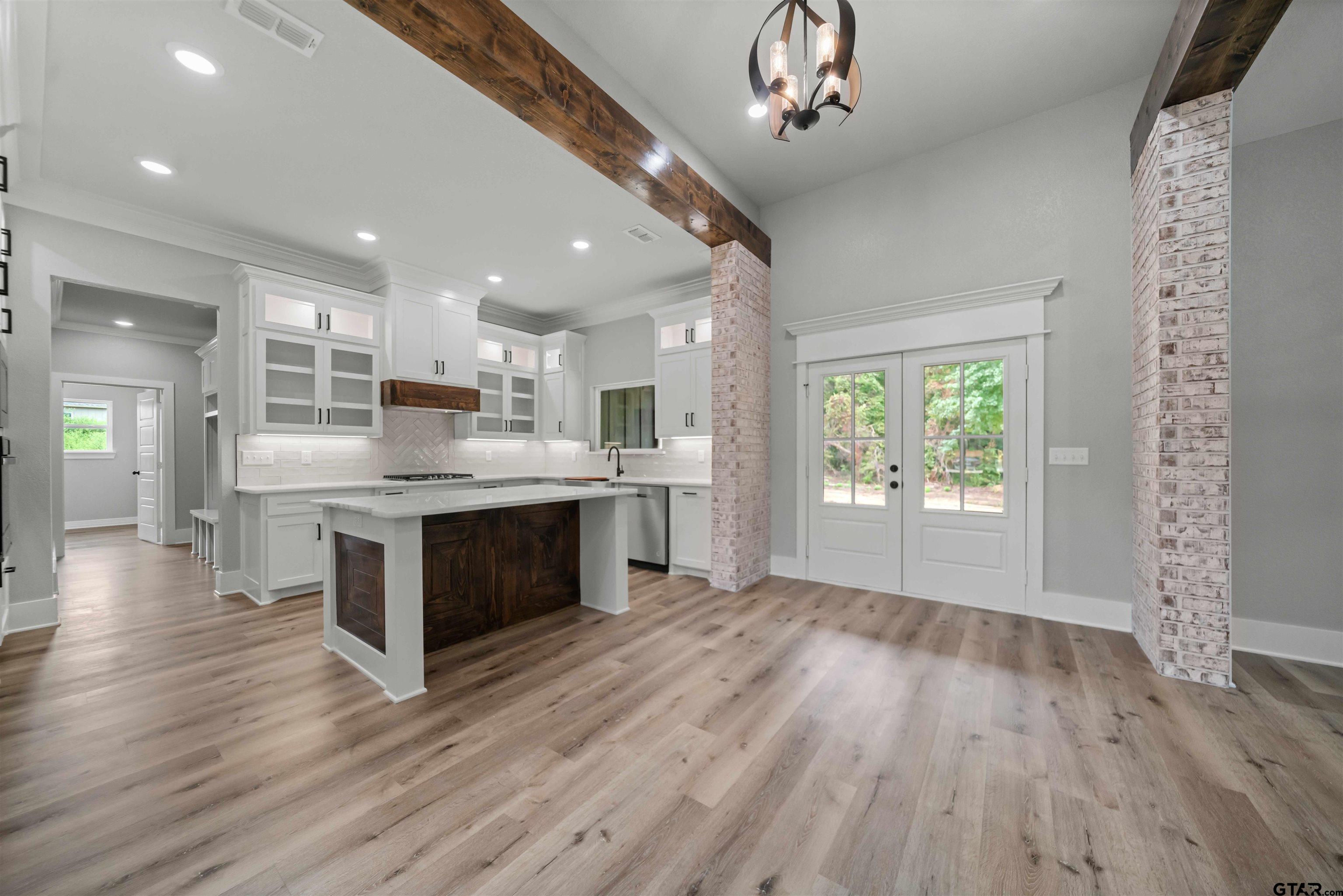 14552 Fallow Lane Tyler, TX 75706 - Photo 18 of 38 a large kitchen with kitchen island white cabinets and wooden floor