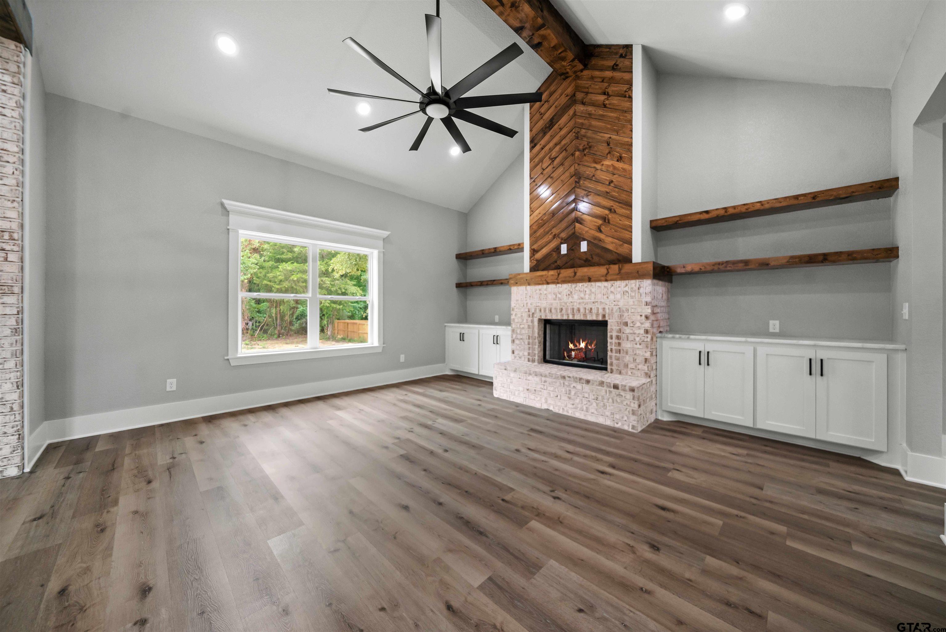 14552 Fallow Lane Tyler, TX 75706 - Photo 26 of 38 an empty room with wooden floor a ceiling fan and windows