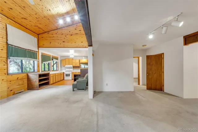 a view of an empty room with furniture and a window