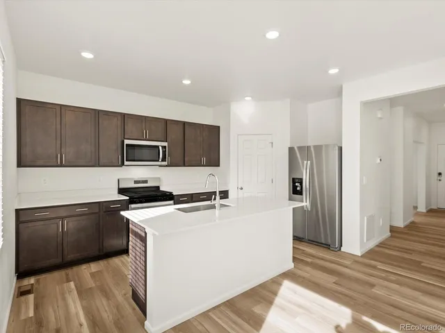 a kitchen with stainless steel appliances a refrigerator stove microwave and cabinets