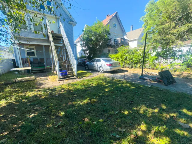 a view of a house with backyard and sitting area