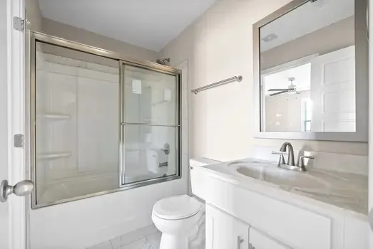 a bathroom with a granite countertop sink toilet and shower