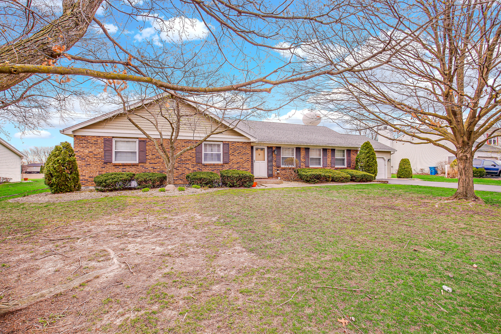 a front view of a house with a yard and potted plants