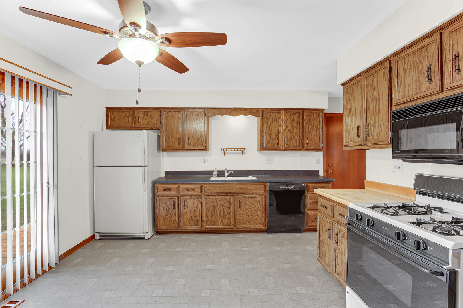 3723 Ronald Road Crete, IL 60417 - Photo 11 of 25 a kitchen with stainless steel appliances granite countertop a stove refrigerator sink and microwave