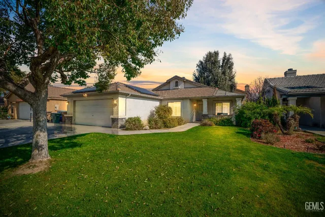 a front view of a house with a garden and yard