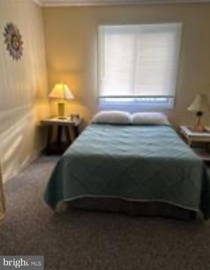 8908 Rusty Anchor Road, Unit 20501 Ocean City, MD 21842 - Photo 11 of 15 a bedroom with a bed and a window