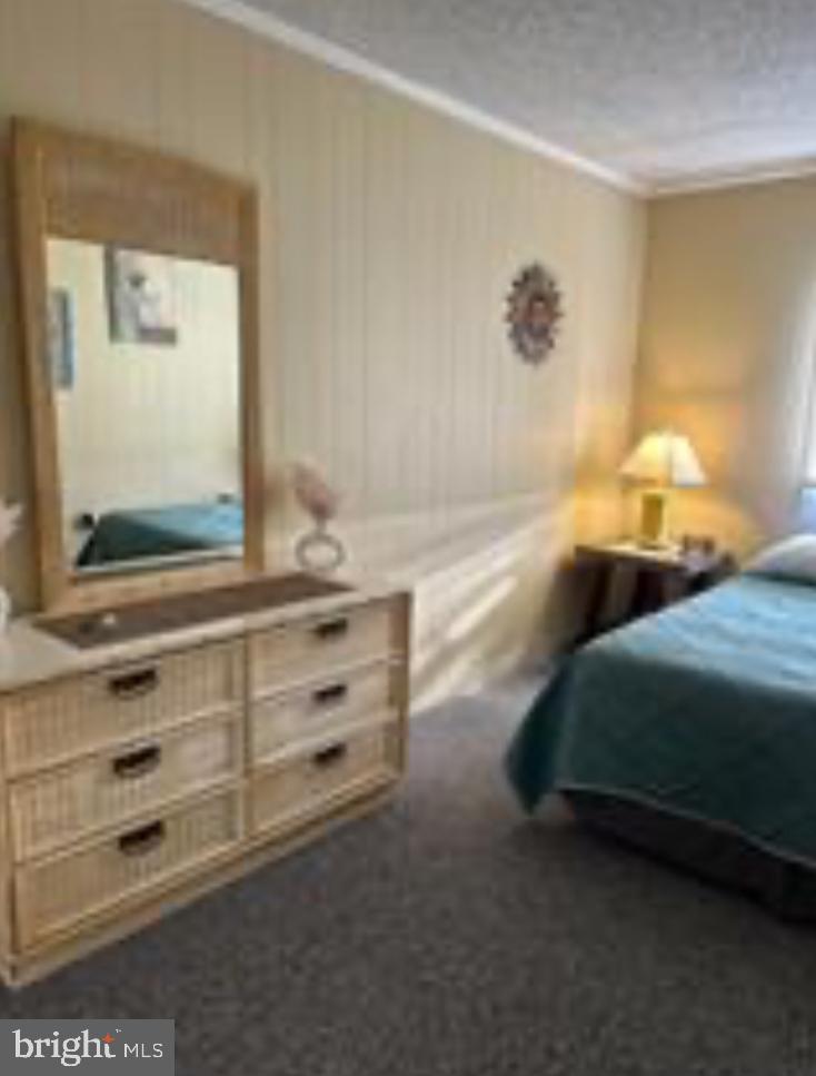8908 Rusty Anchor Road, Unit 20501 Ocean City, MD 21842 - Photo 12 of 15 a bedroom with a bed and a dresser