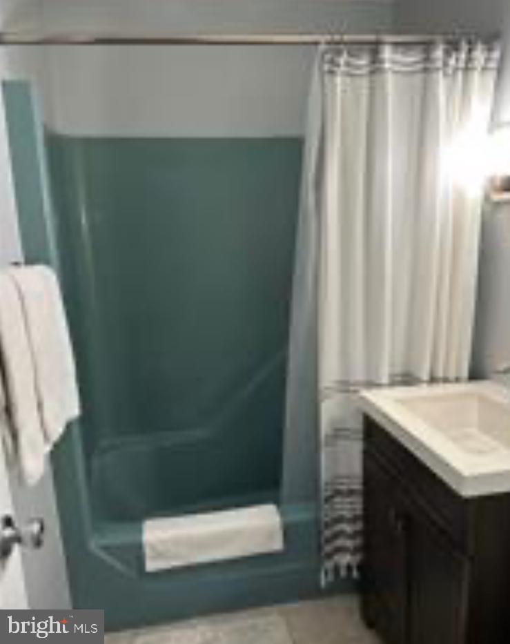 8908 Rusty Anchor Road, Unit 20501 Ocean City, MD 21842 - Photo 13 of 15 a bathroom with a shower curtain and sink