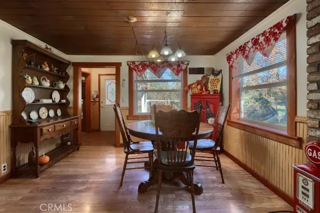 a view of a dining room with furniture a chandelier and wooden floor