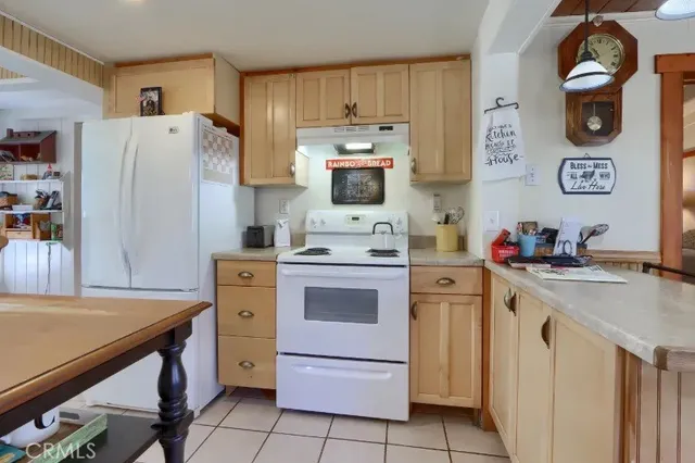 a kitchen with a refrigerator and a stove top oven