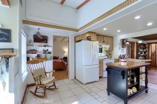 a kitchen with stainless steel appliances granite countertop a table chairs and a refrigerator