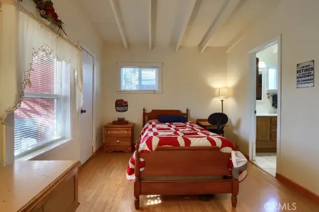 a bedroom with a bed and wooden floor