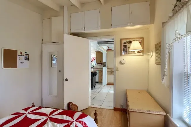 a hallway view with white cabinets and wooden floor