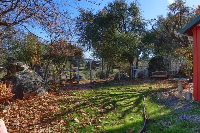 a view of a backyard with table and chairs and a large tree