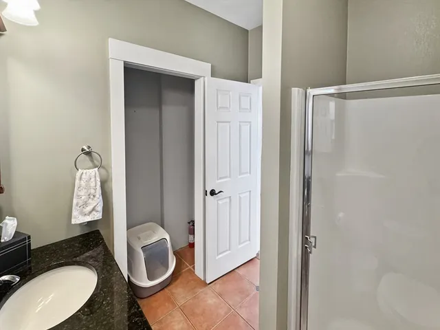 a bathroom with a granite countertop toilet sink and shower