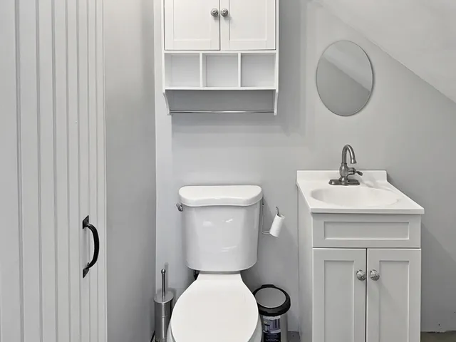 a bathroom with a toilet a sink and a mirror