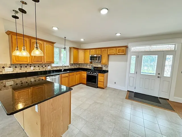 a kitchen with stainless steel appliances granite countertop a sink counter space cabinets and a large window