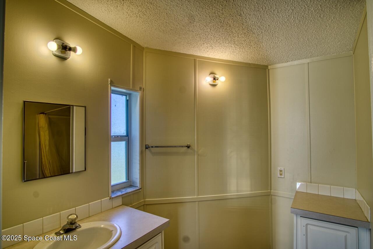 2390 Coconut Palm Drive Palm Bay, FL 32905 - Photo 13 of 27 a bathroom with a sink and a mirror