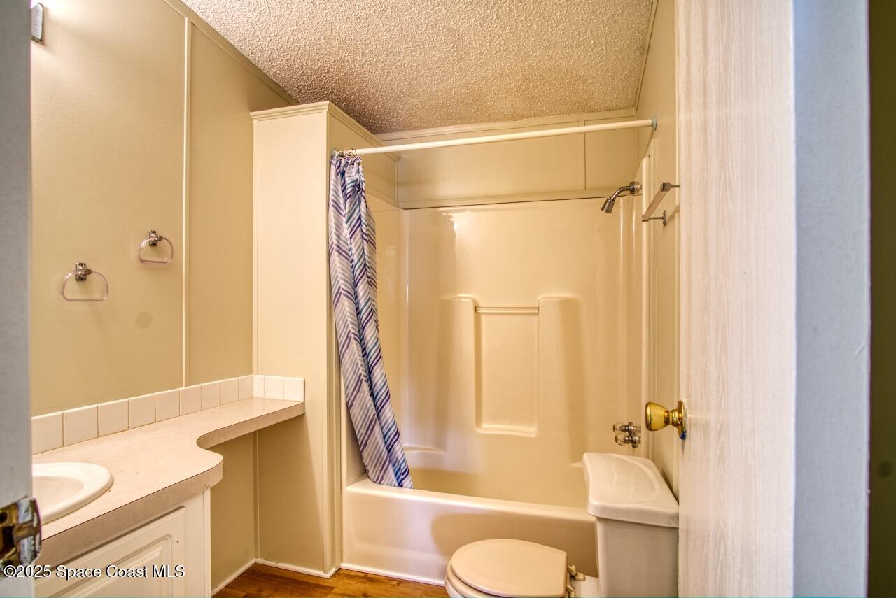 2390 Coconut Palm Drive Palm Bay, FL 32905 - Photo 15 of 27 a bathroom with a shower curtain and a bath tub