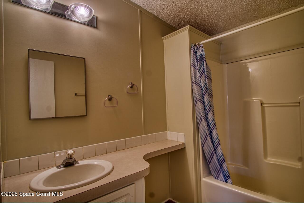 2390 Coconut Palm Drive Palm Bay, FL 32905 - Photo 16 of 27 a bathroom with a sink and a mirror