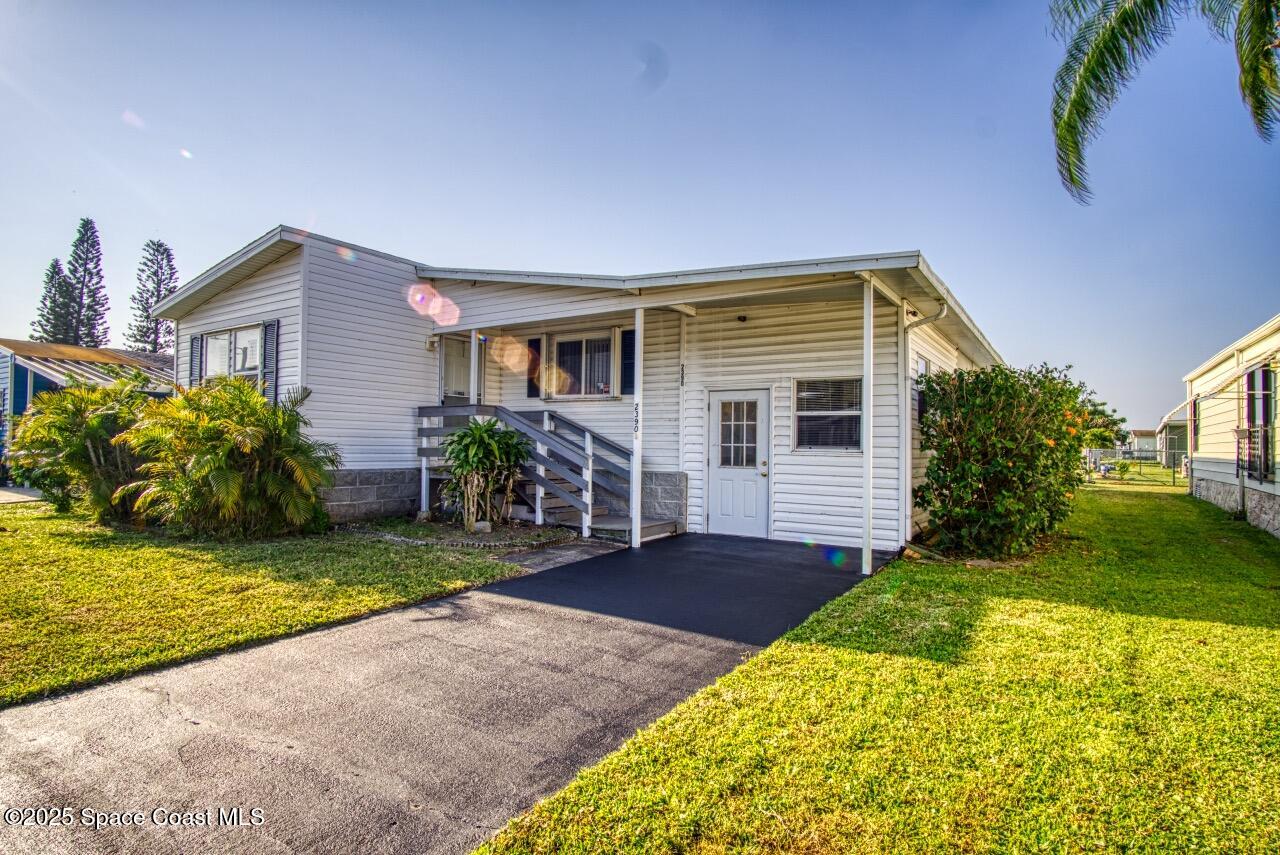2390 Coconut Palm Drive Palm Bay, FL 32905 - Photo 2 of 27 a front view of a house with garden