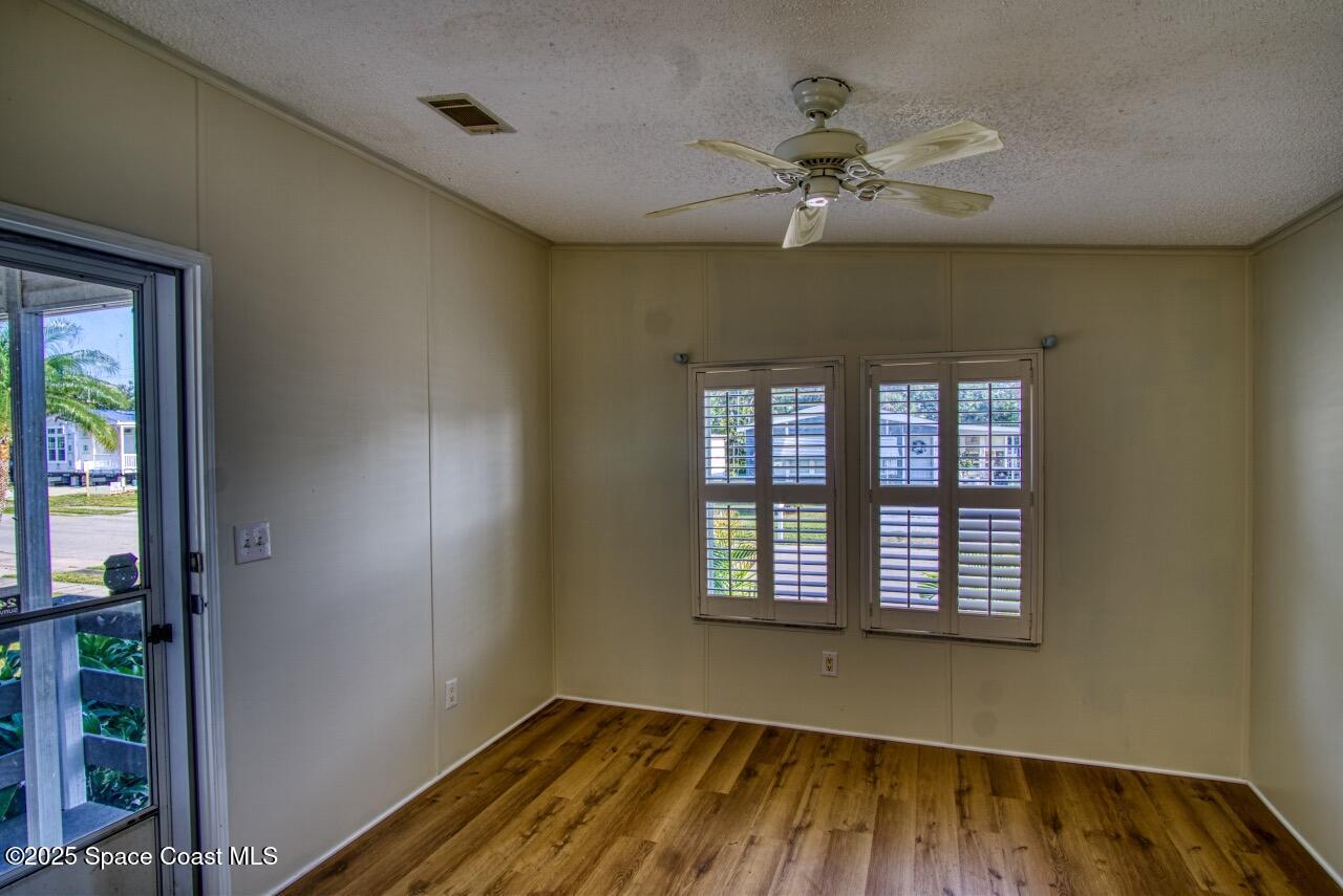 2390 Coconut Palm Drive Palm Bay, FL 32905 - Photo 4 of 27 wooden floor in an empty room with a window