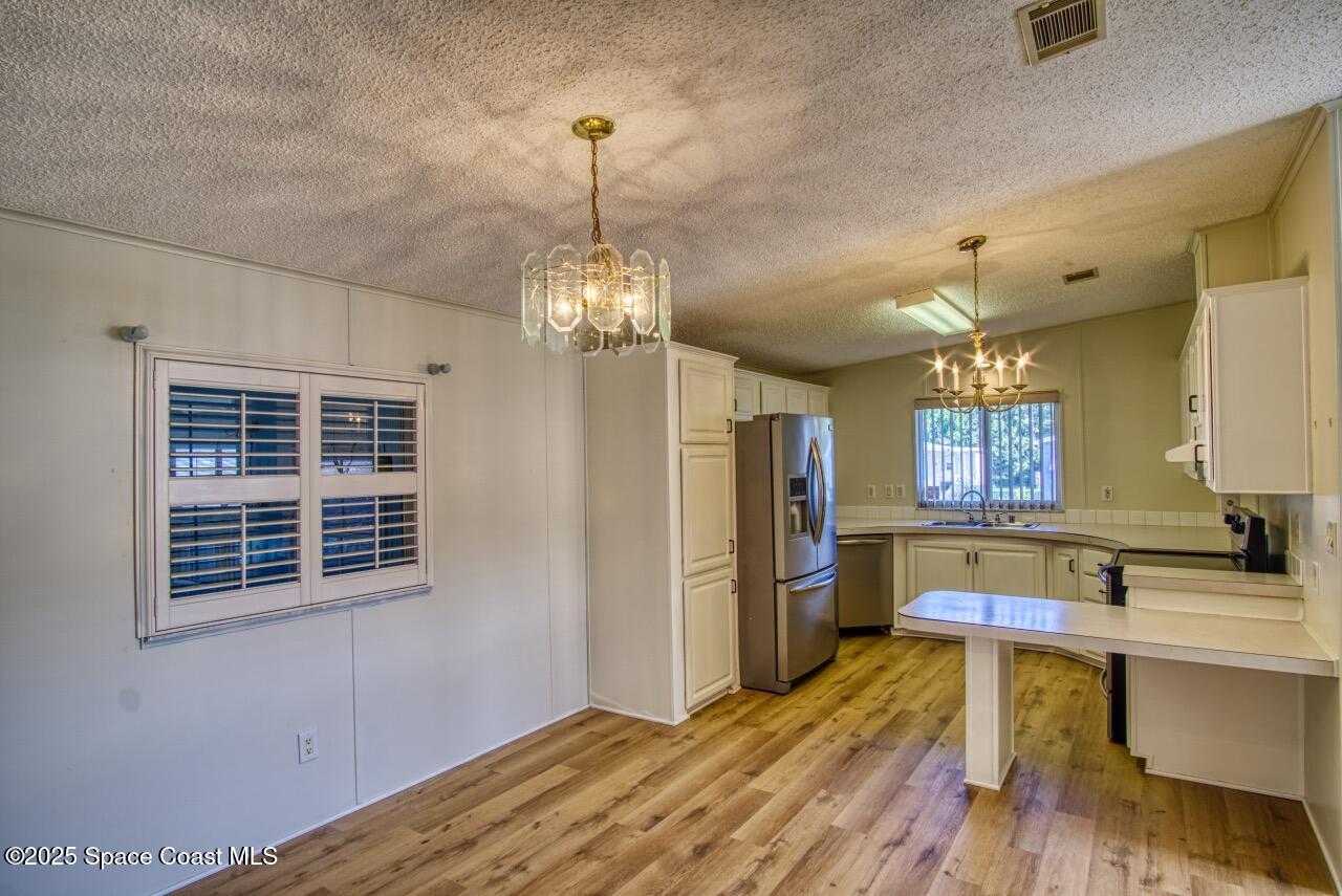 2390 Coconut Palm Drive Palm Bay, FL 32905 - Photo 7 of 27 a view of a kitchen counter space with furniture and wooden floor