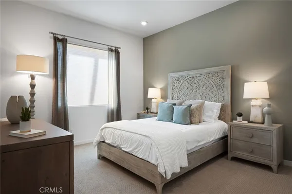 a large bed sitting in a bedroom next to a window