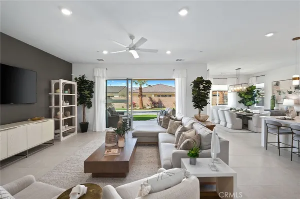 a living room with furniture a flat screen tv and a large window