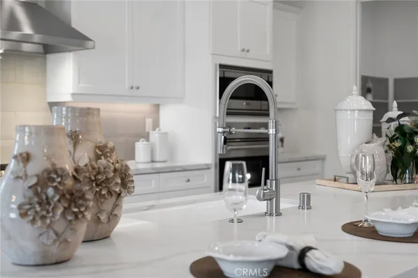 a large white kitchen with stainless steel appliances granite countertop lots of counter space sink and cabinets