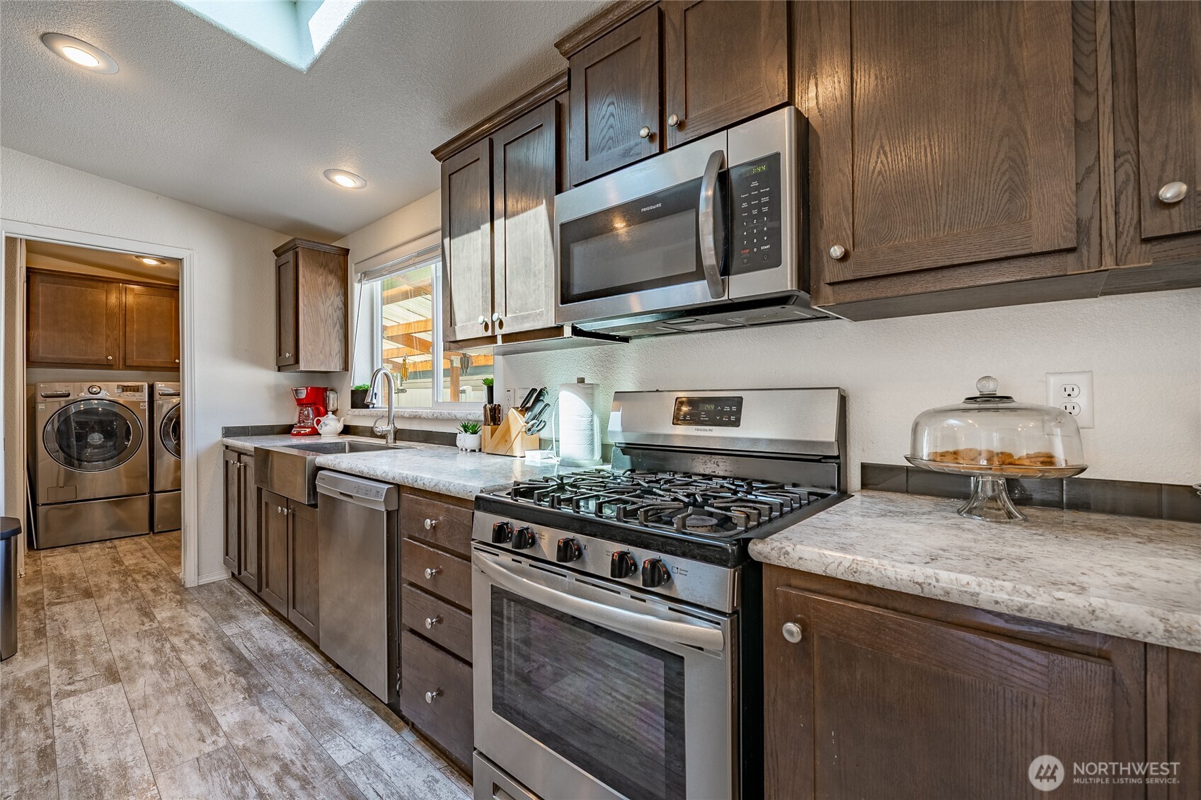 6350 Portal Way, Unit 83 Ferndale, WA 98248 - Photo 13 of 40 a kitchen with granite countertop a sink a stove top oven and wooden cabinetry