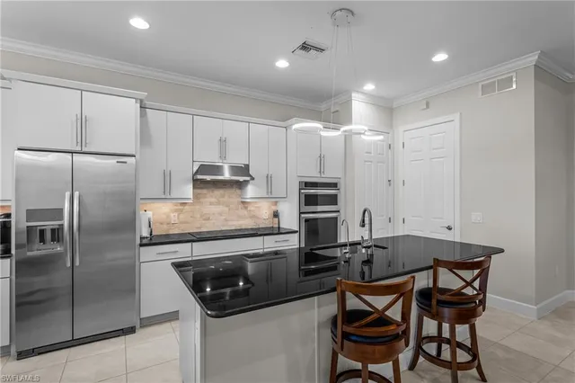 a kitchen with kitchen island a counter space a sink appliances and cabinets