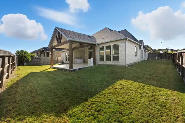 a view of a big house with a big yard and potted plants