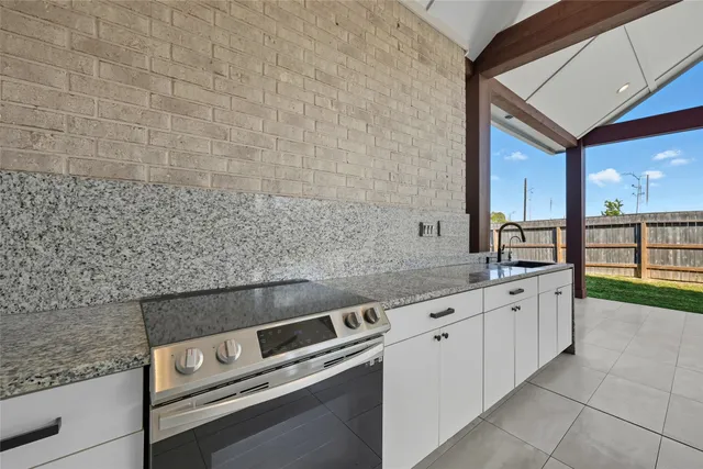 a kitchen with granite countertop a sink and a stove