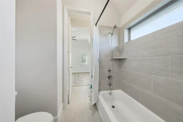 a bathroom with a bathtub toilet and shower