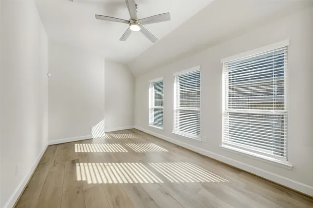a view of a livingroom with wooden floor and a ceiling fan