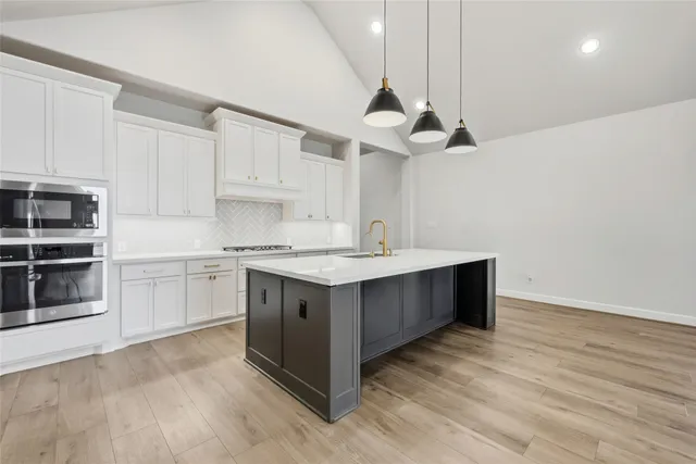 a kitchen with a stove cabinets and wooden floor