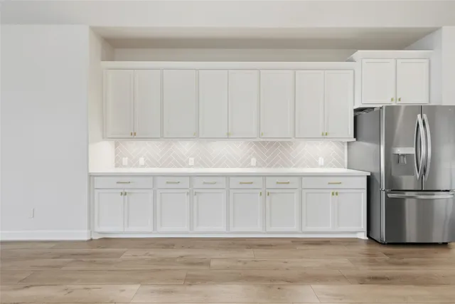 a kitchen with white cabinets and stainless steel appliances