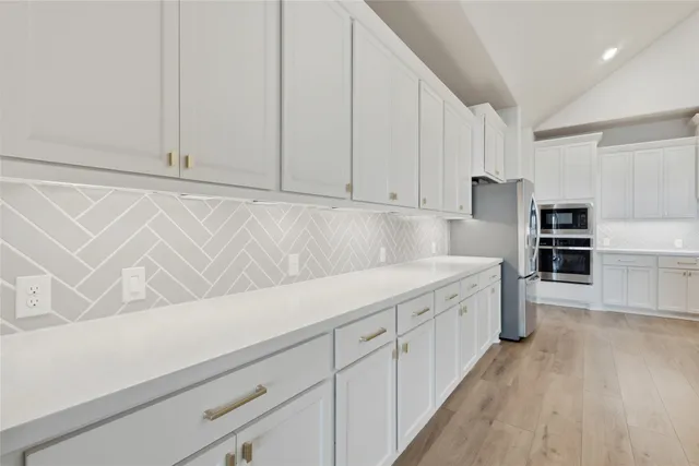 a kitchen with cabinets and wooden floor