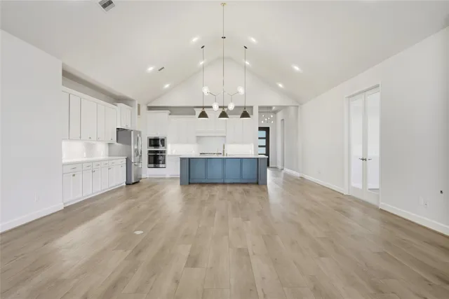 a large room with kitchen view and a window