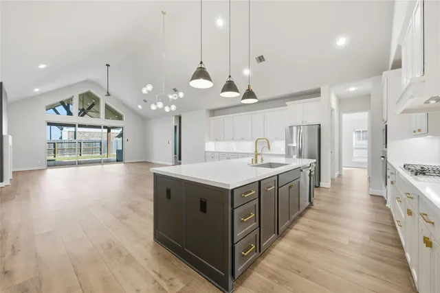 a kitchen with stainless steel appliances granite countertop a stove and a wooden floors
